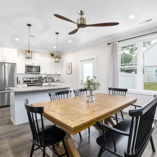 Destratificateur chrome et bois dans un salon avec cuisine ouverte 